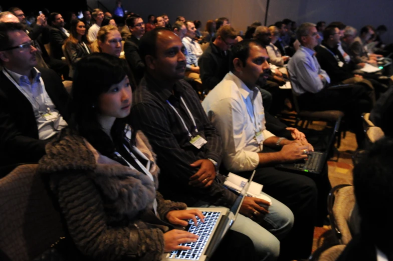 the audience is watching the presentation on their laptops