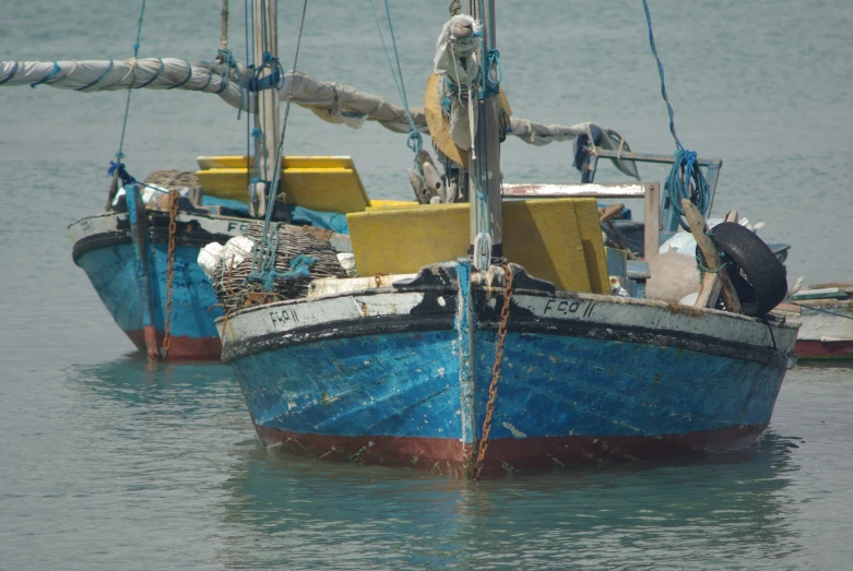 two blue and yellow boats are docked in the water