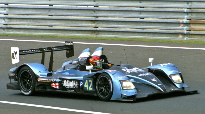 a race car driving on the track during daytime