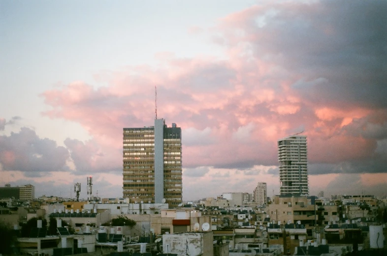 the city is seen from atop a hill, on top of buildings