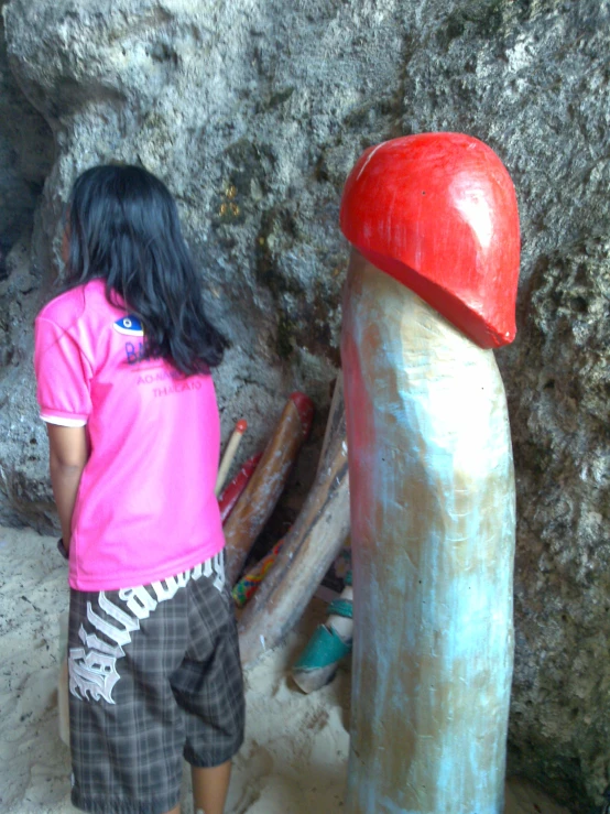 two children standing near the base of a large mushroom shaped sculpture