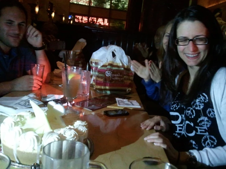 several people sitting at a table with drinks in front of them