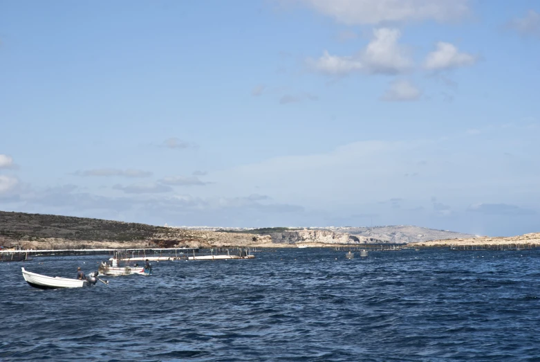 two white boats are floating on a body of water