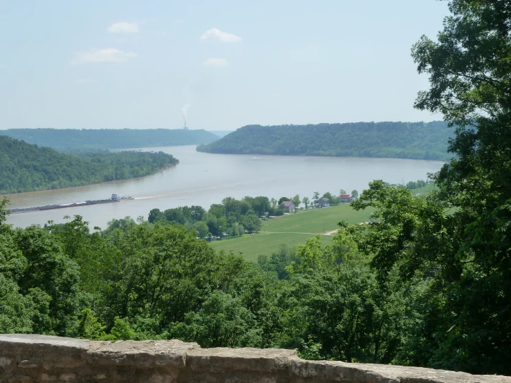 a scenic view of a river running close to a lush green forest