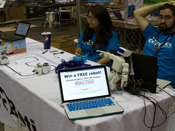 the two people are sitting at the table looking at their laptop