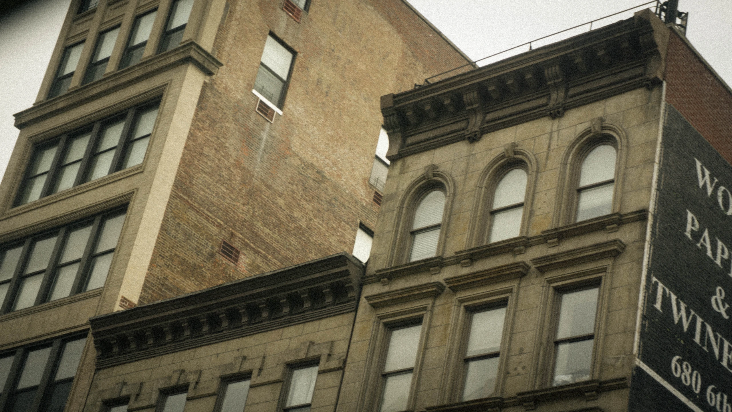 the corner of a tall building with windows on it