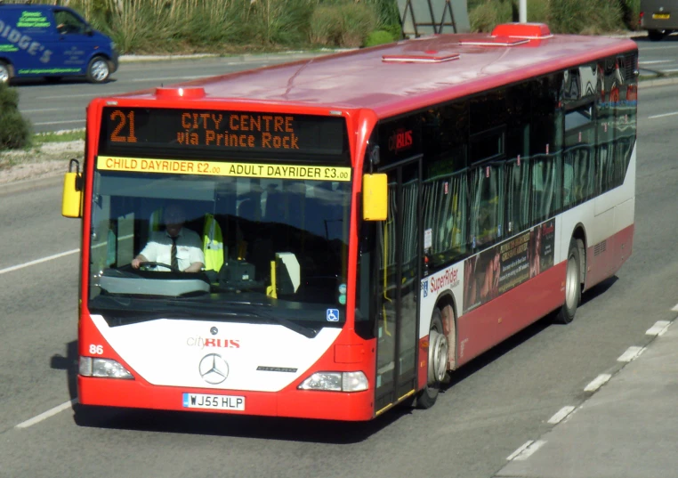 a red and white bus traveling on a street