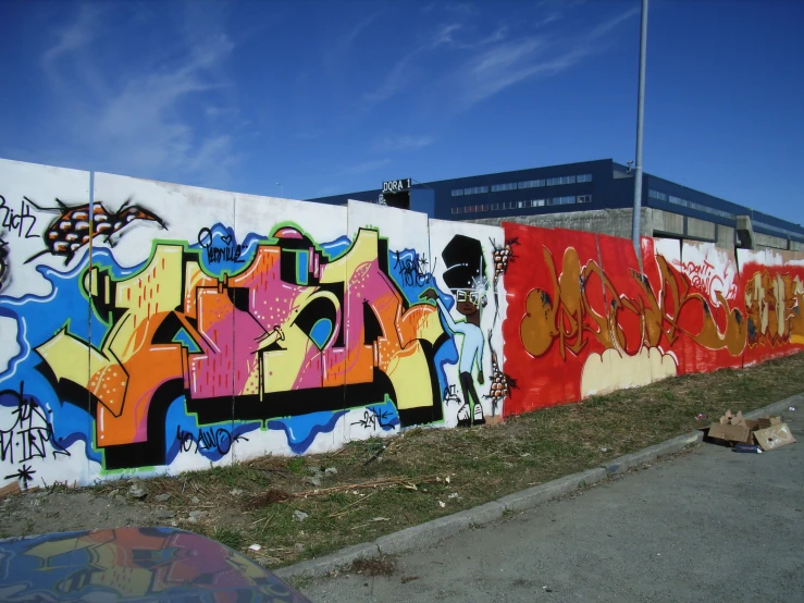 a wall with various colorful spray paint on it