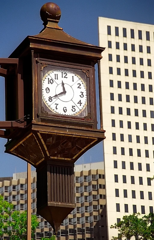 a large clock on top of a pole near buildings