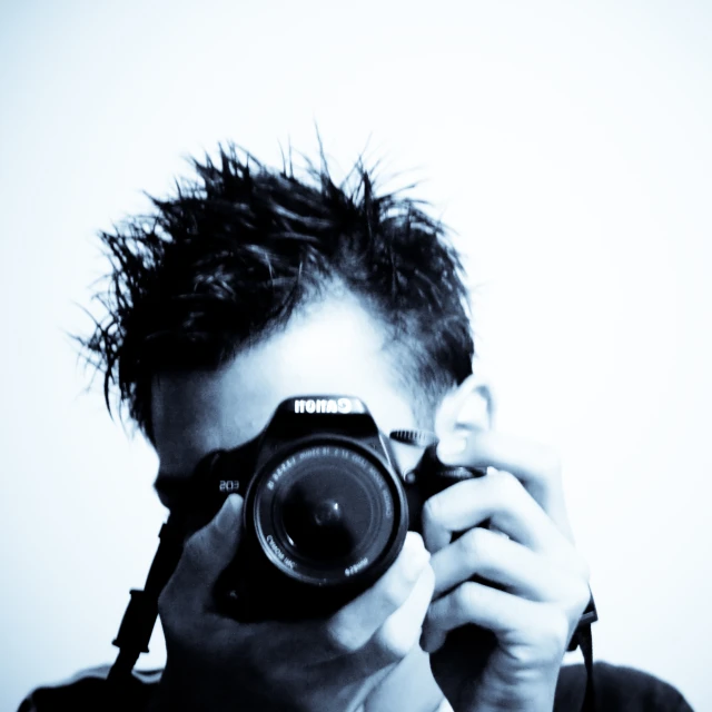 a man holding a camera up to his face