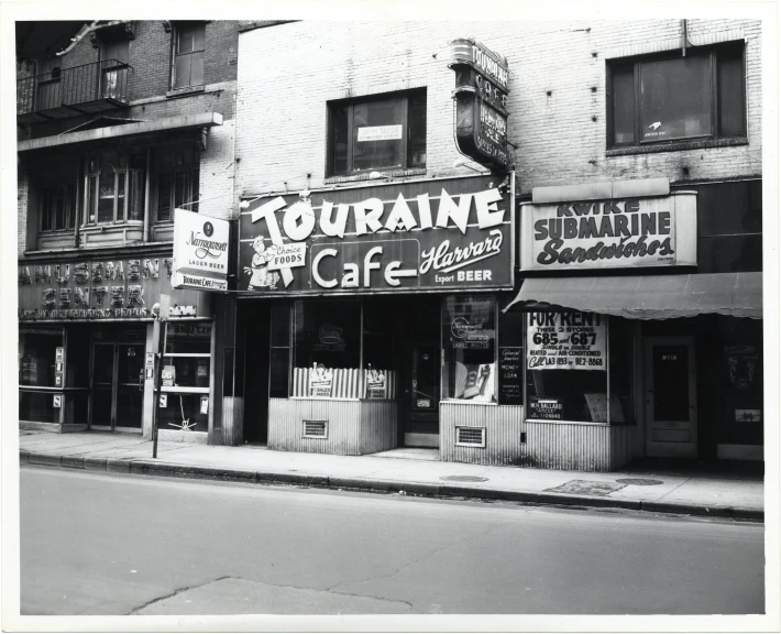 the storefronts of the building have many signs