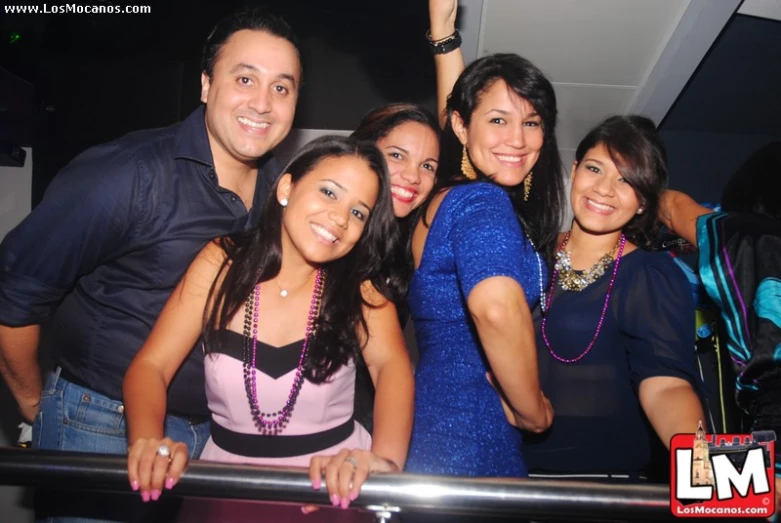 a group of people pose on top of a railing