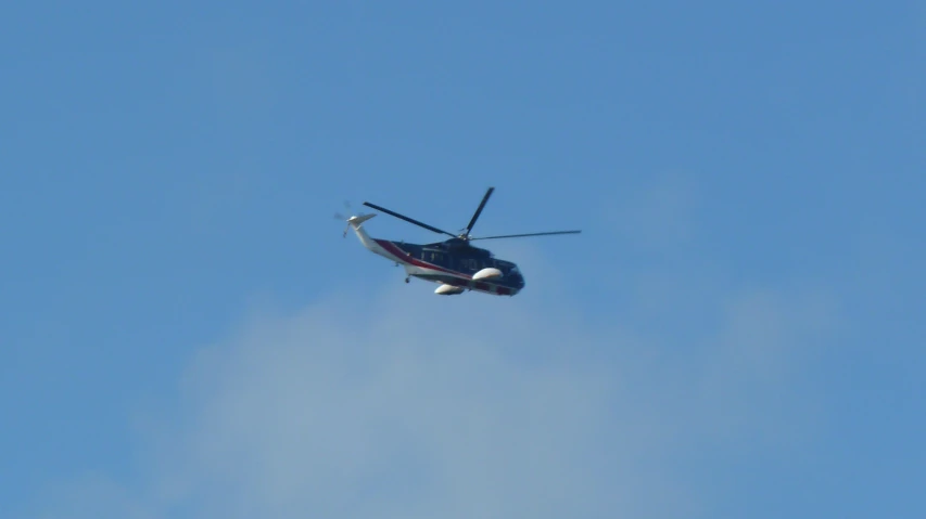 a helicopter flying in a blue sky with two propellers