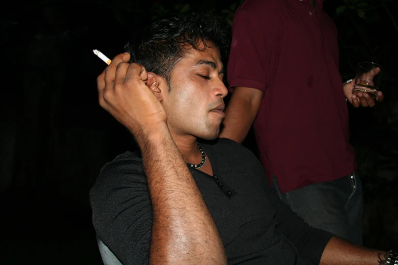 a man in black shirt smoking a cigarette