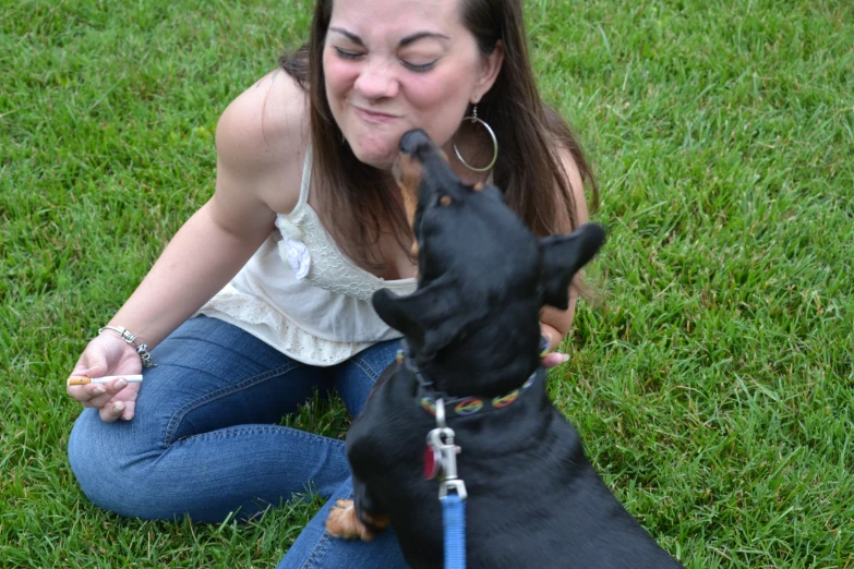 woman pets a dog and licks it on the face