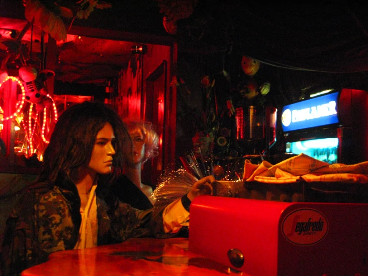 a young woman is sitting at a restaurant table and has her hands out