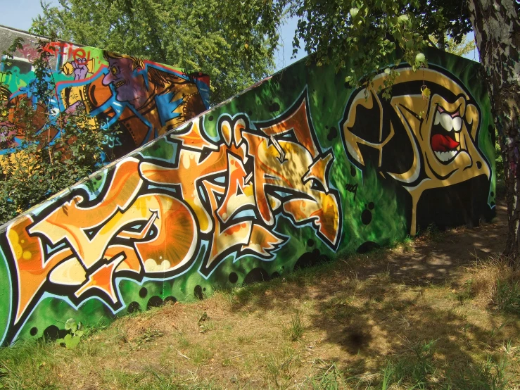 a long rail painted with colorful graffiti under a tree