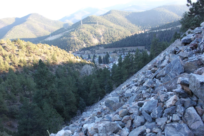 a group of rocks and grass in front of the mountains