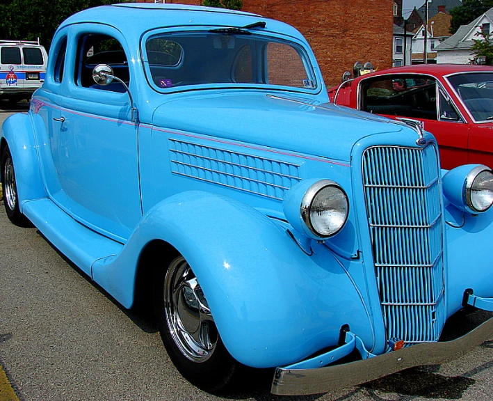 vintage blue car in parking lot near other old cars