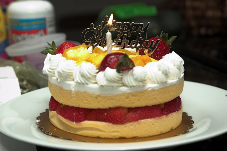 a birthday cake with strawberries and strawberrys on it