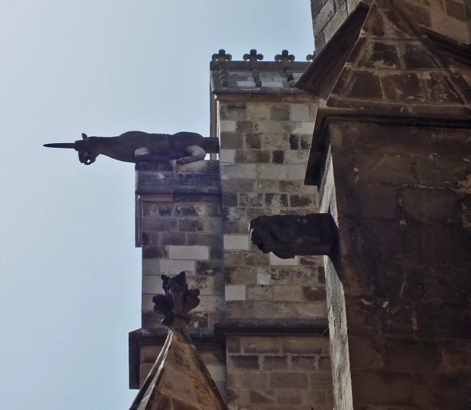 a tower with two statues on it and a statue of a bear on top