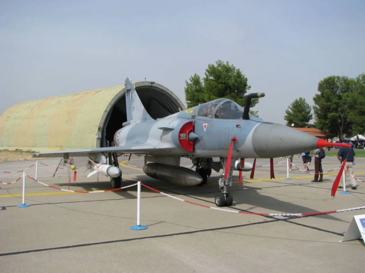 a gray fighter jet sitting in the middle of a runway