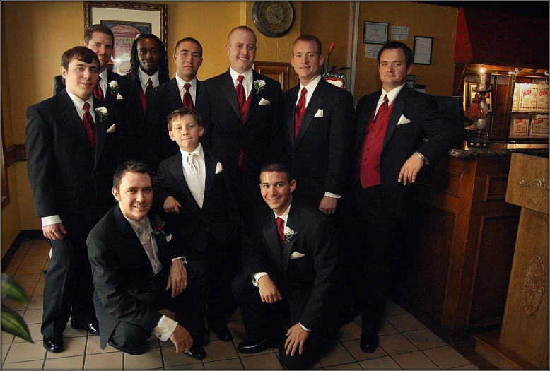 a group of men in black and red suits posing for a po