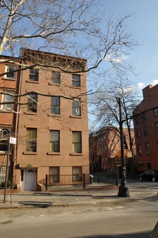 large tan building with many windows next to a street