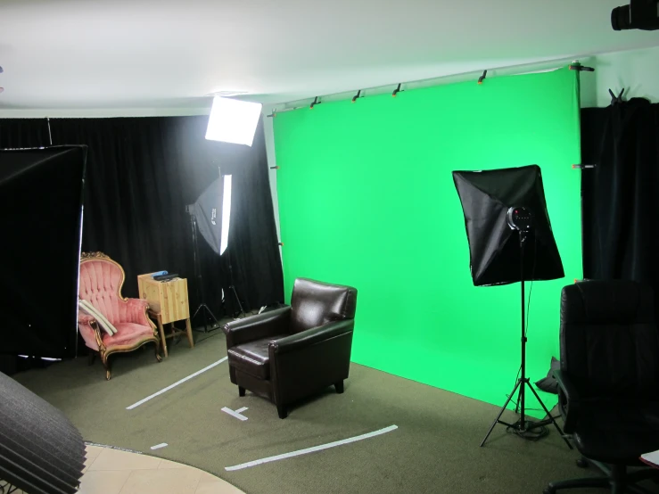 a green screen in an office with two chairs