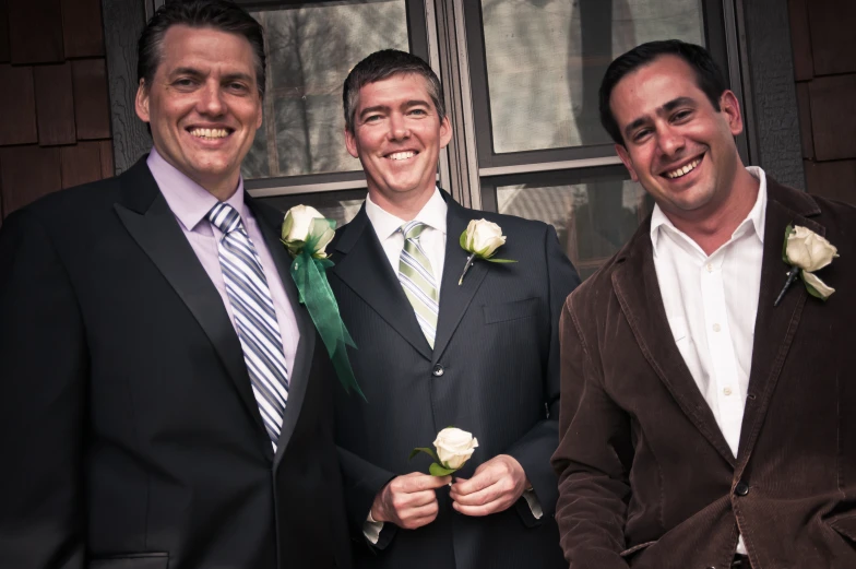 a trio of men in suits posing for a po