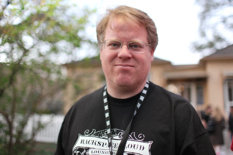 a man wearing glasses and a lanyard around his neck