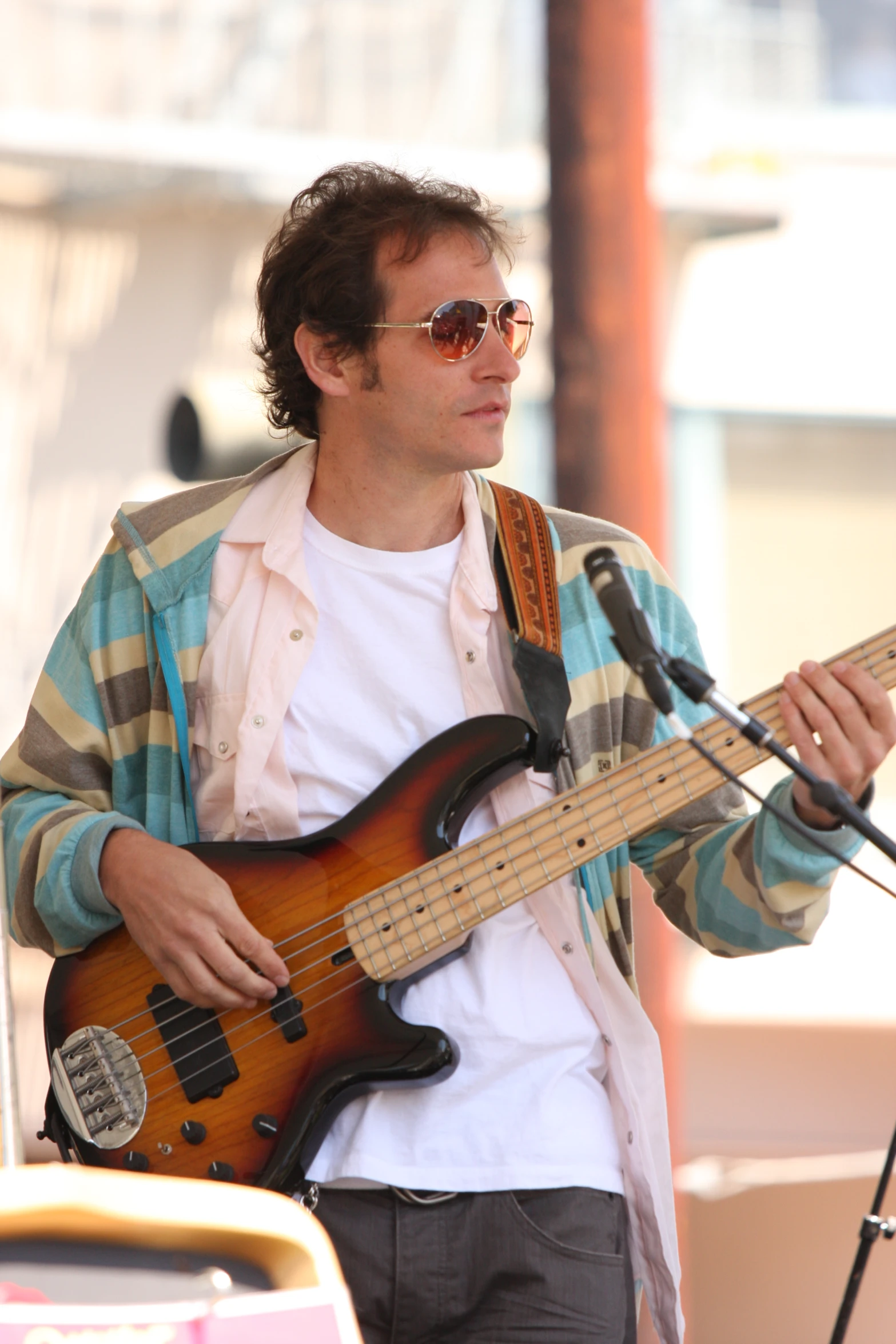 a man playing bass guitar during a microphone interview