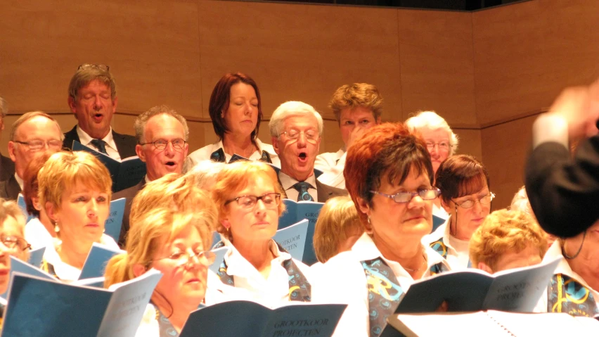 group of adults in choir singing with adult singing on chair