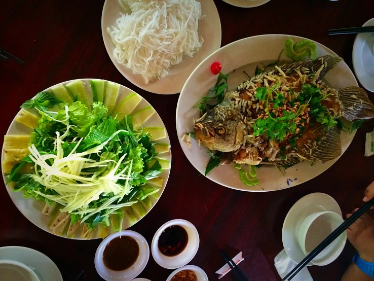 an overhead view of three plates of food on a wooden table