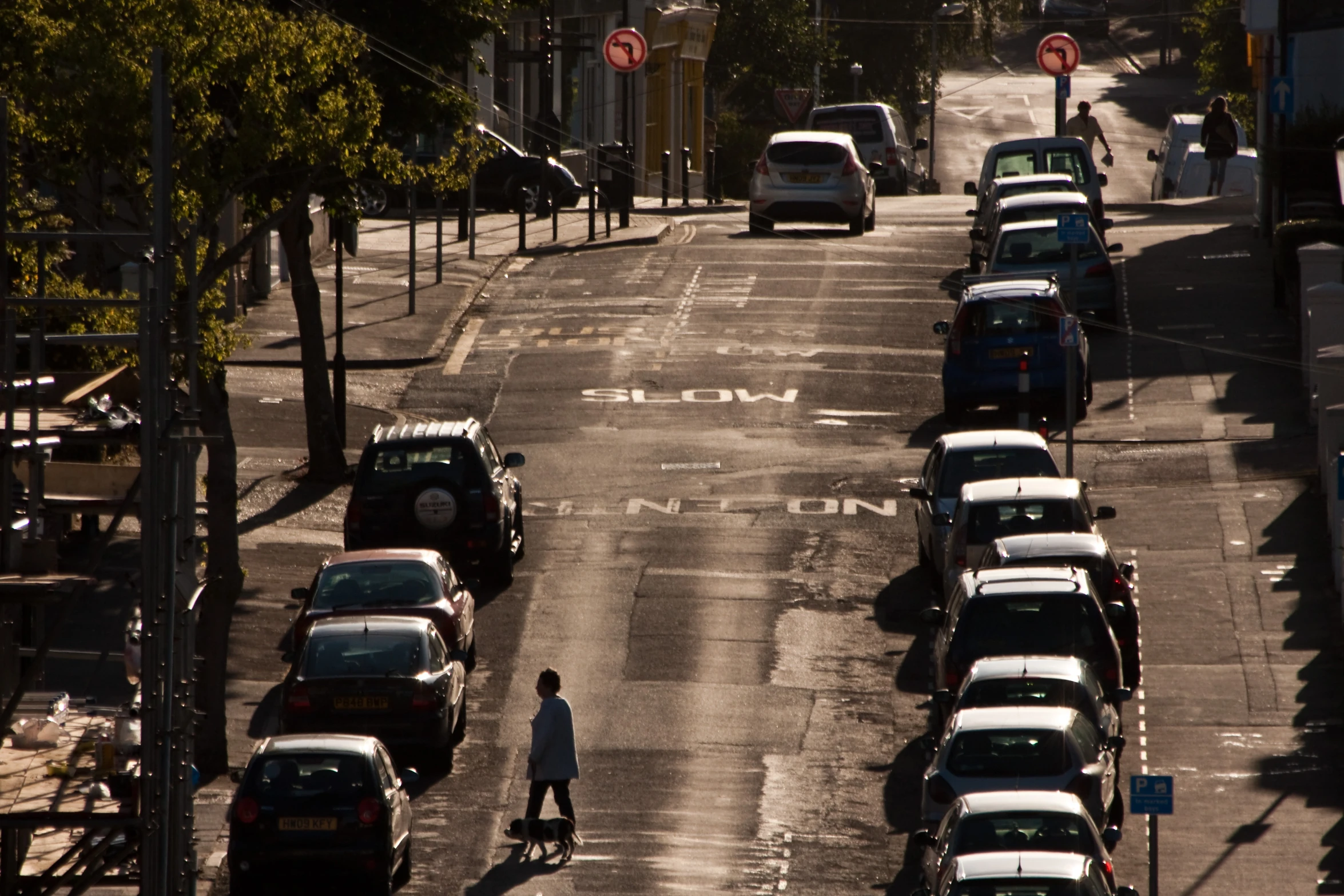 an overhead view of a road with cars and people walking