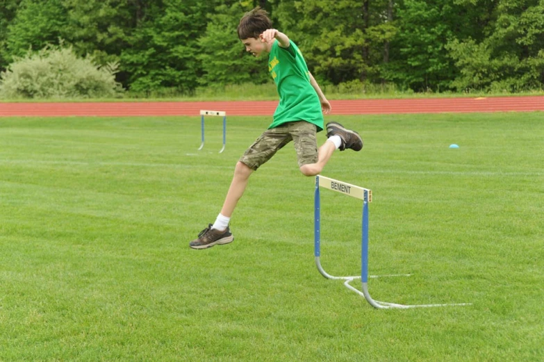 a boy with an arm ce stands on the parallel bar in a field