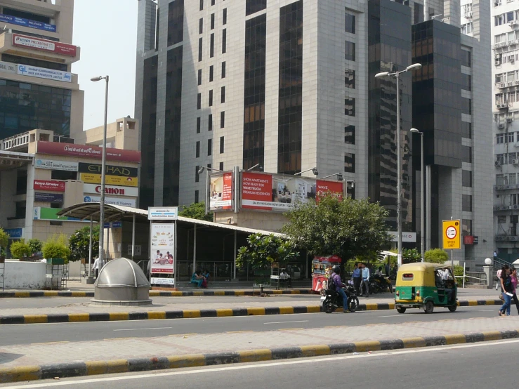 a motorbike, moped and mopeds are on the road near tall buildings