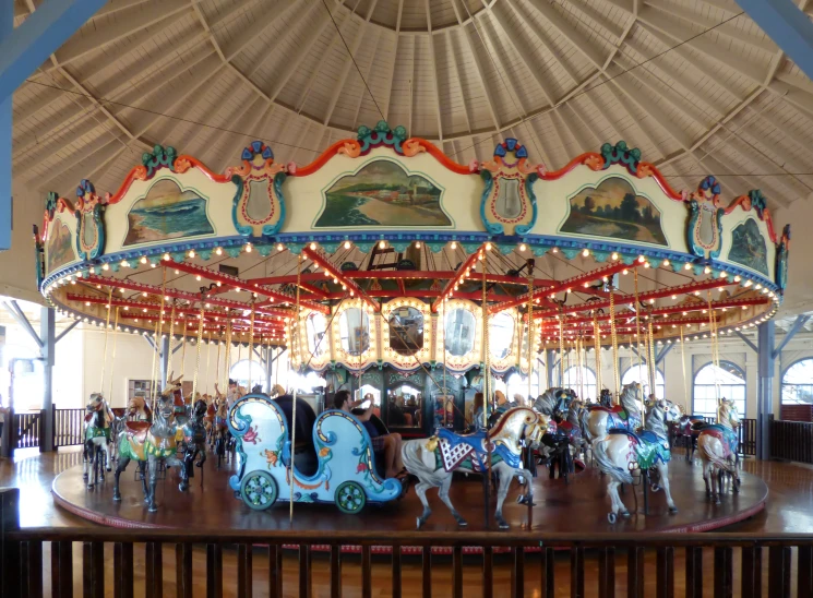 a carousel in a large building with people sitting on it