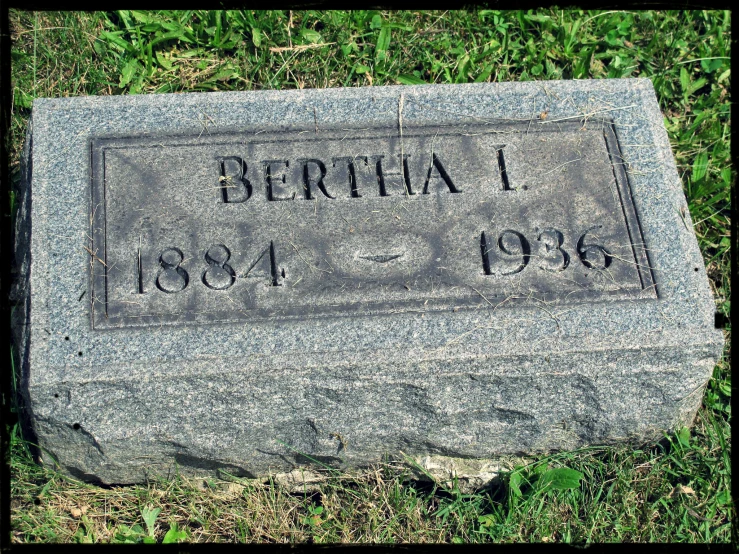 the memorial stone in the grass has a message