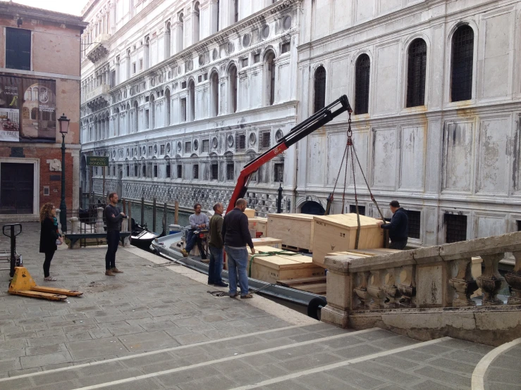 a crane lifting a crate out of the water onto a city street