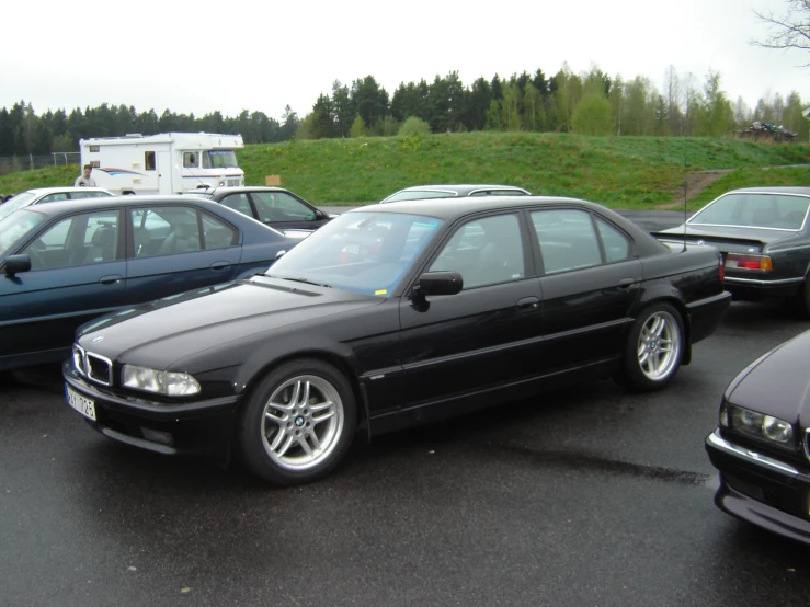 three parked bmws in a parking lot on a very overcast day