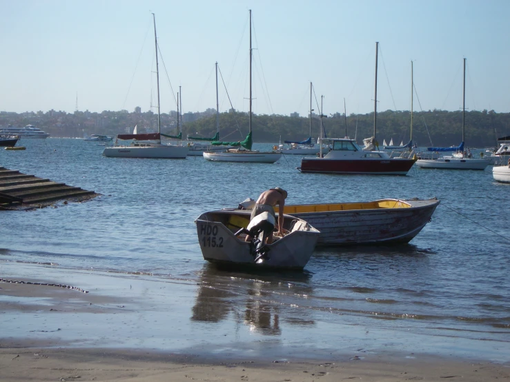 a small boat floating in the ocean next to other boats