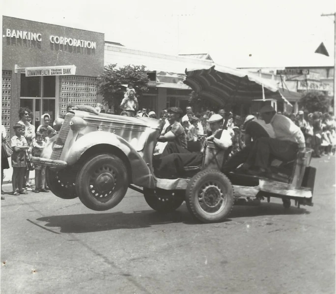 a vintage po shows men and women on a truck in the street