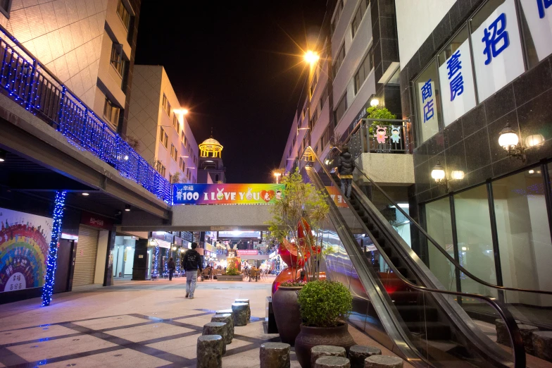 an empty street is filled with buildings decorated with holiday lights