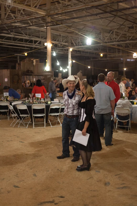 the two ladies are standing near the man dressed in cowboy gear