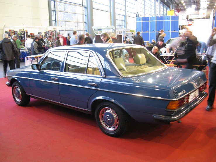 people looking at a vintage car on display