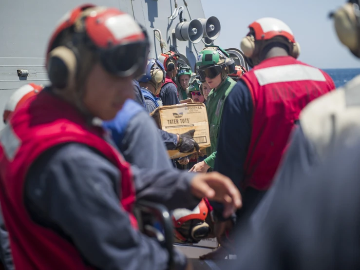 a group of people wearing safety jackets on a ship