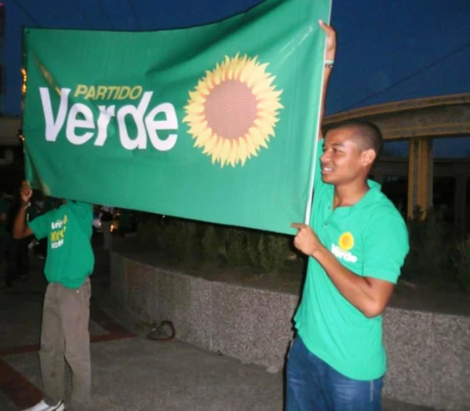 a man holds a green flag that says meride