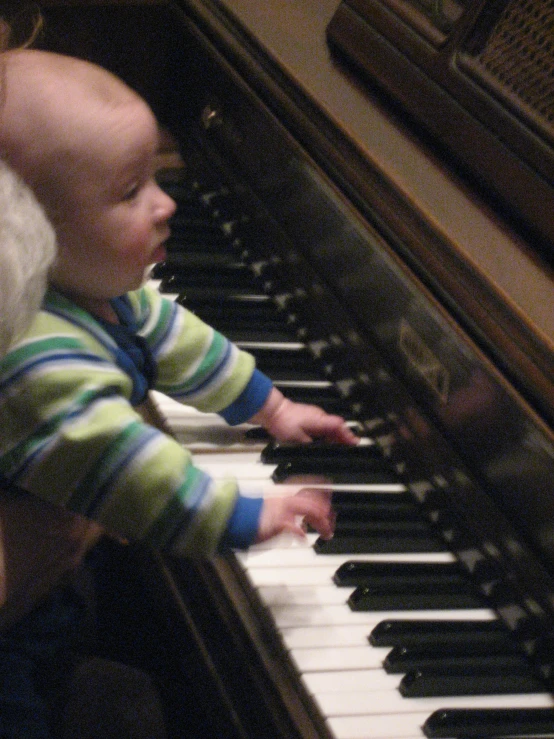 a child and its parent playing a piano