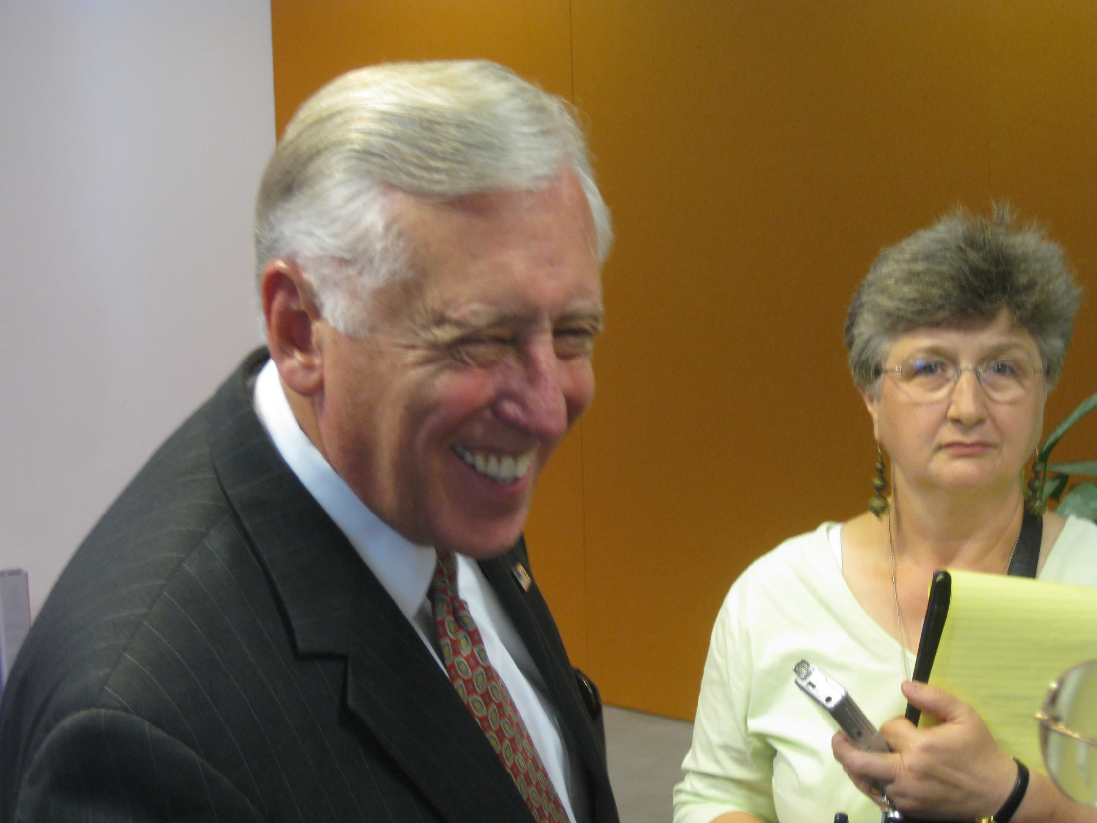 an older couple smiles as they hold wine glasses